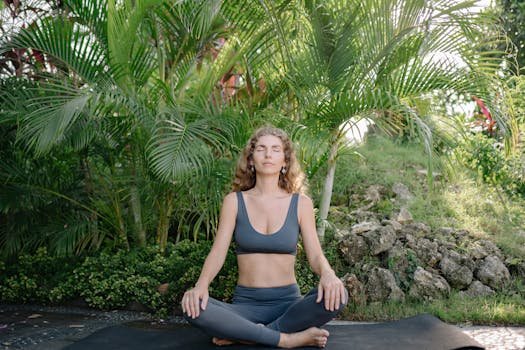 A serene woman practices meditation in a lush, tropical garden, embodying peace and wellness.