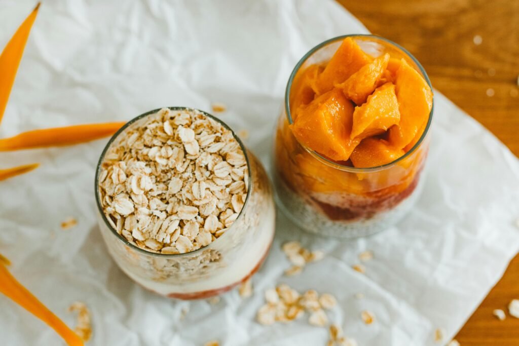 Top view of creamy mango and oat desserts in glasses, perfect for a summer treat.